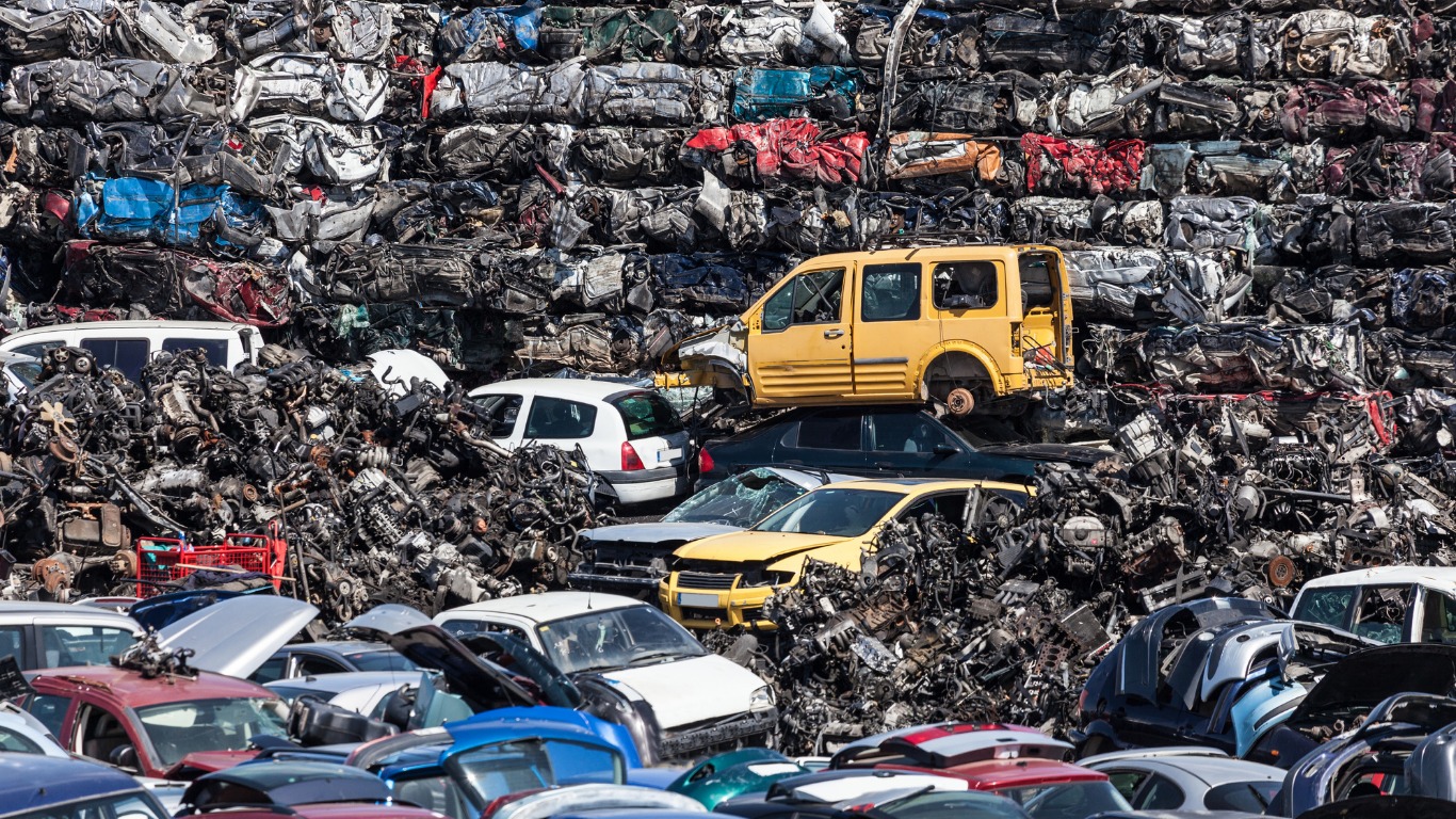 wracked cars in huge dumpster